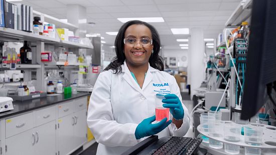 Smiling Woman in lab holding fluid - Ecolab Diversity, Equity & inclusion