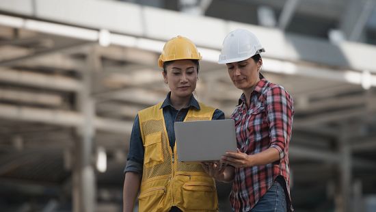 Two women talking in manufacturing setting 