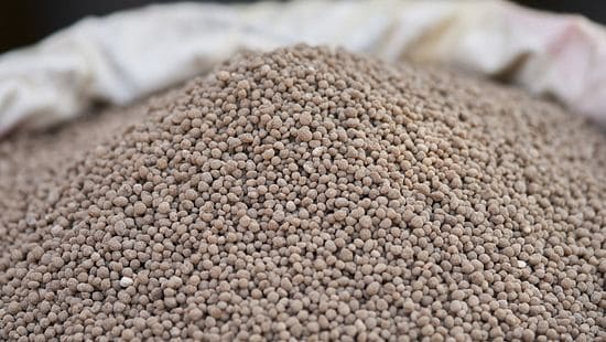 Large mounds of fertilizer pellets in a thick sack.