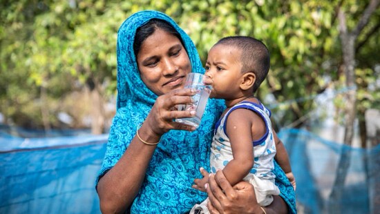 Woman and child drinking glass of water